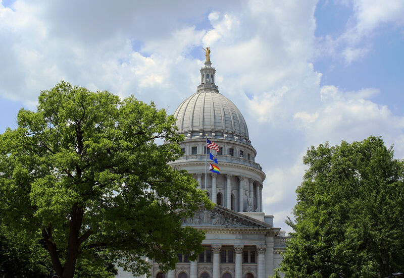 The Progress Pride Flag flies over the Wisconsin Capitol in June 2023. Wisconsin lawmakers held a hearing Thursday on two bills that would limit the rights of trans and non-binary people under the age of 18.. (Photo by Henry Redman/Wisconsin Examiner)miner)