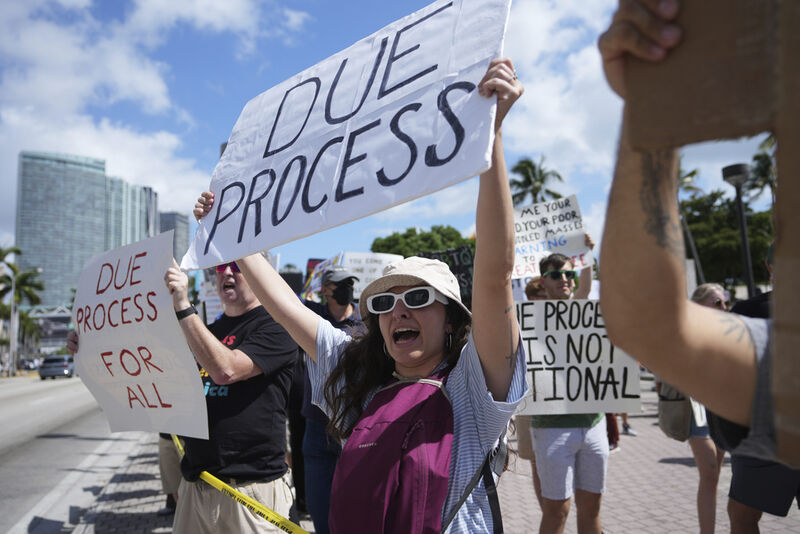 FILE - People hold signs and chant slogans during a protest against the Trump administration, Saturday, April 19, 2025, in Miami. (AP Photo/Lynne Sladky, File)
