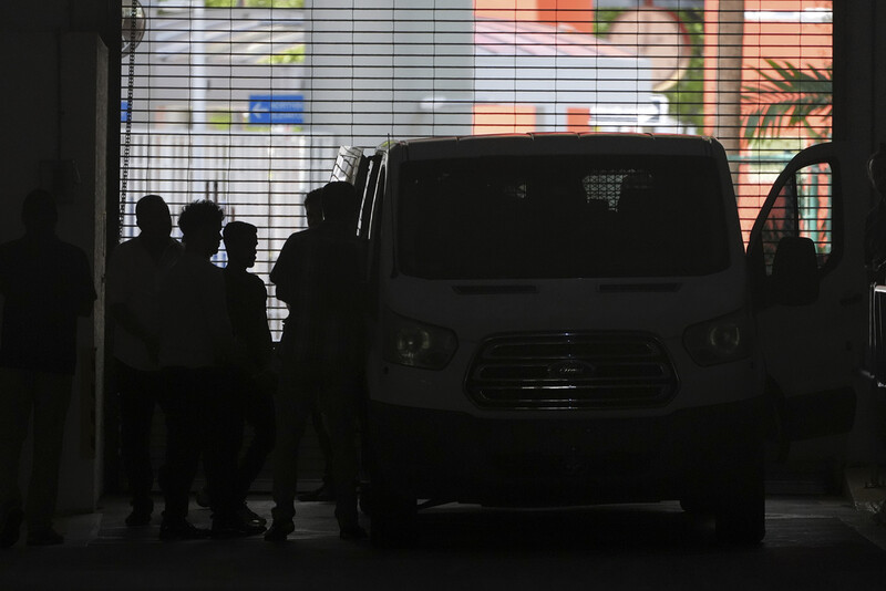 Plainclothes agents from U.S. Immigration and Customs Enforcement load people detained at the Miami Immigration Court into a Department of Homeland Security van in Miami, on Wednesday, May 21, 2025. (AP Photo/Rebecca Blackwell)
