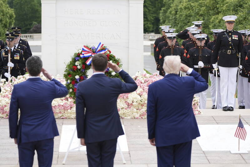 President Donald Trump, standing right, salutes at the Tomb of the Unknown Soldier, on Memorial Day at Arlington National Cemetery, in Arlington, Va., Monday, May 26, 2025. (AP Photo/Jacquelyn Martin)