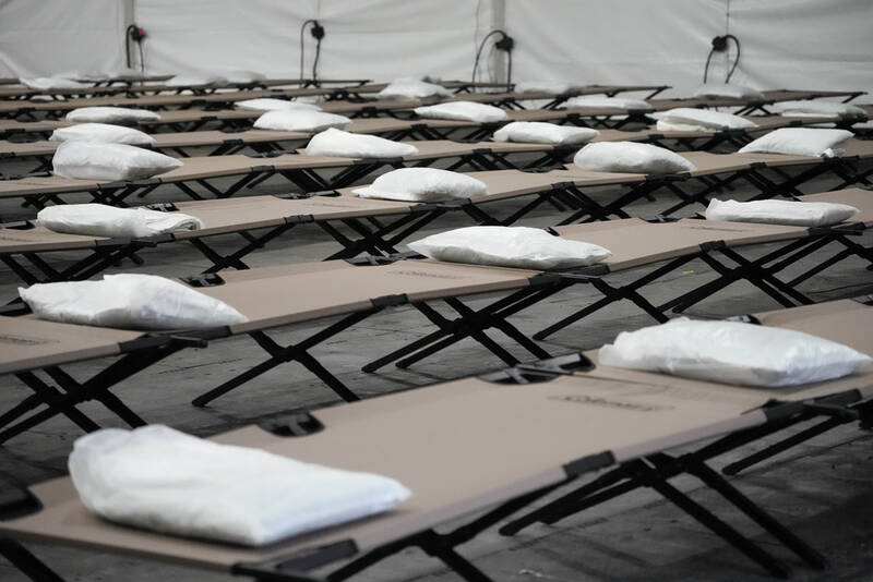FILE - Bags containing bedding are placed on cots inside the dormitory tent during a tour of a shelter New York City is setting up to house up to 1,000 migrants, in the Queens borough of New York, Aug. 15, 2023. (AP Photo/Mary Altaffer, File)