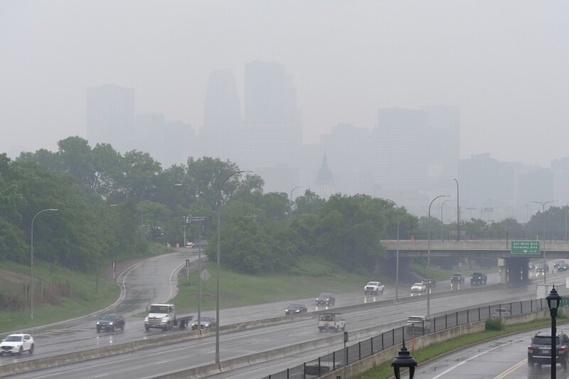 Smoke from wildfires burning in Canada and rain obscures the downtown skyline of Minneapolis, Minn., on Tuesday, June 3, 2025. (AP Photo/Mark Vancleave)