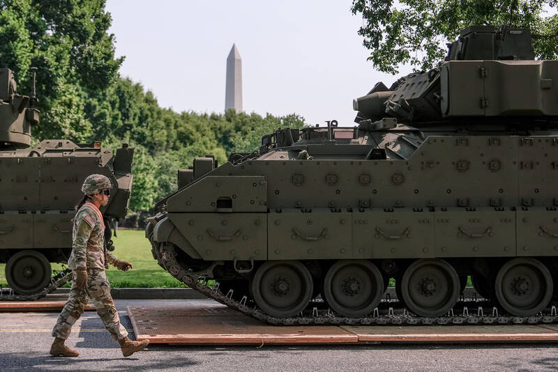 A U.S. Army soldier walks past a Bradley fighting vehicle staged in West Potomac Park ahead of an upcoming military parade commemorating the Army's 250th anniversary and coinciding with Donald Trump's 79th birthday, Wednesday, June 11, 2025, in Washington. (AP Photo/Julia Demaree Nikhinson)