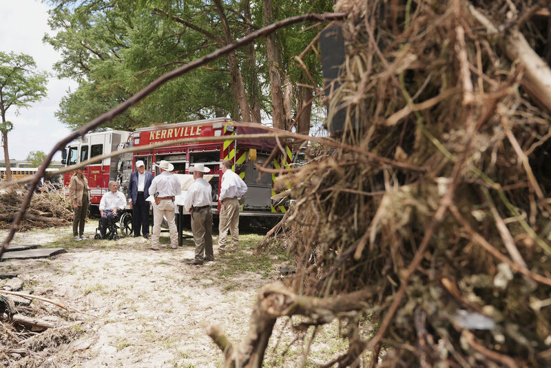 First lady Melania Trump, from left, Texas Gov. Greg Abbott and President Donald Trump are briefed on flood damage in Kerrville, Texas, Friday, July 11, 2025. (AP Photo/Jacquelyn Martin)