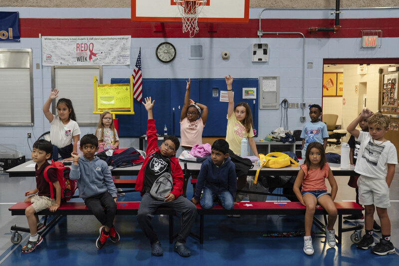 Children raise their hands while participating in activities during the East Providence Boys and Girls Club Summer Camp at Emma G. Whiteknact Elementary School on Thursday, July 10, 2025, in Providence R.I. (AP Photo/Sophie Park)