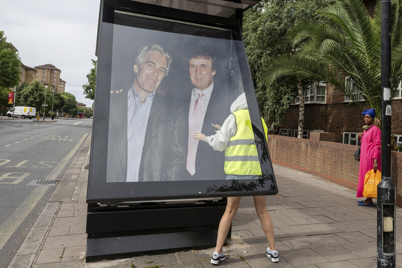 Activists put up a poster showing President Donald Trump and Jeffrey Epstein near the U.S. Embassy in London, Thursday, July 17, 2025.(AP Photo/Thomas Krych)