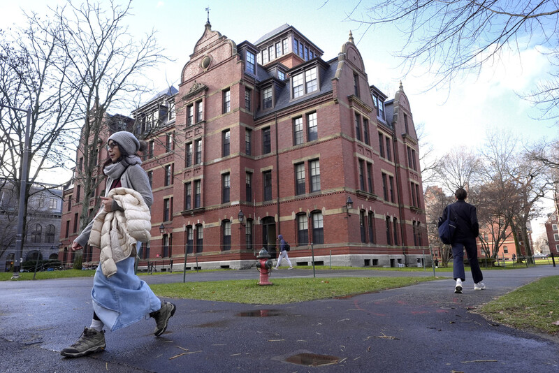 FILE - People walk between buildings on Harvard University campus, Dec. 17, 2024, in Cambridge, Mass. (AP Photo/Steven Senne, File)