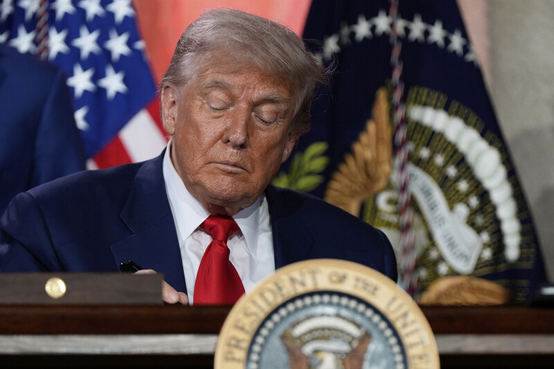 President Donald Trump signs executive orders after speaking during an AI summit at the Andrew W. Mellon Auditorium, Wednesday, July 23, 2025, in Washington. (AP Photo/Julia Demaree Nikhinson)