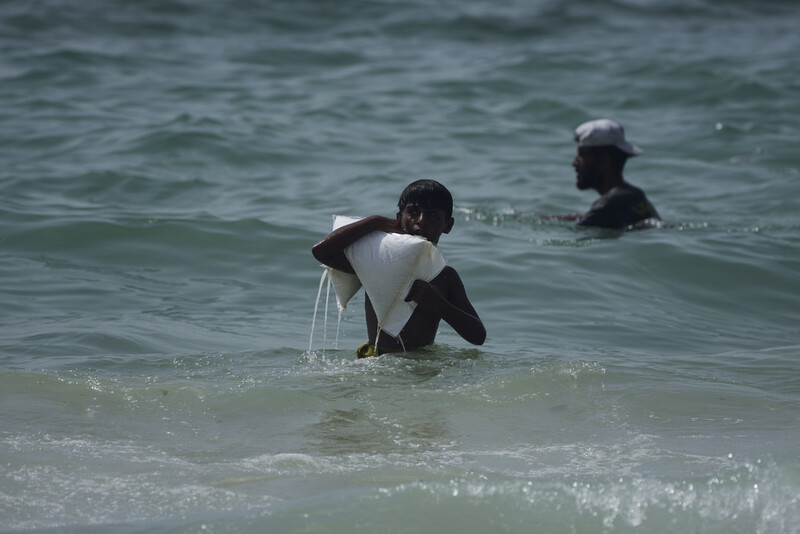 A Palestinian youth carries a sack of aid that landed in the Mediterranean Sea after being airdropped over central Gaza, at the shore of Zawaida, Gaza Strip Tuesday, July 29, 2025. (AP Photo/Abdel Kareem Hana)