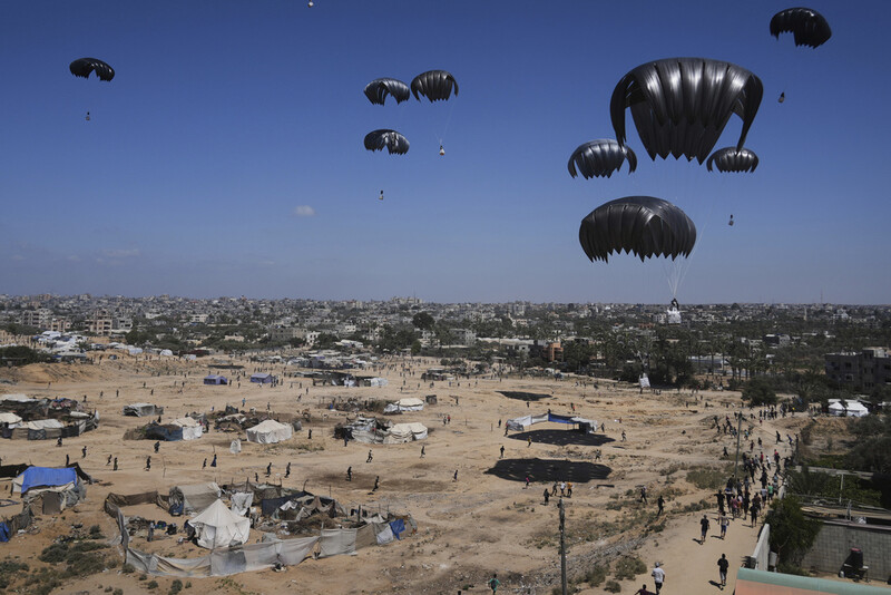 Palestinians rush to collect humanitarian aid airdropped into Zawaida in central Gaza Strip, Thursday, July 31, 2025. (AP Photo/Abdel Kareem Hana)