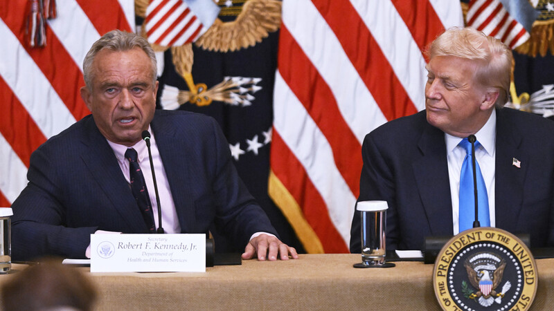Health and Human Service Secretary Robert F. Kennedy, Jr., left, speaks at an event in the East Room of the White House, Wednesday, July 30, 2025, in Washington, as President Donald Trump, looks on. (AP Photo/John McDonnell)