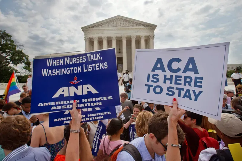 Supporters of the Affordable Care Act hold up signs as the opinion for health care is reported outside of the Supreme Court in Washington, June 25, 2015. Jacquelyn Martin/AP Photo