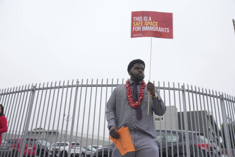 Teacher Naim Muhammad holds a sign supporting immigrants on the first day of school Thursday, Aug. 14, 2025, in Los Angeles. (AP Photo/Marcio Jose Sanchez)