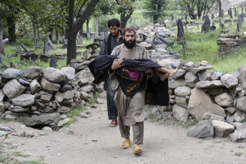 An injured person is carried to a military helicopter that landed to evacuate injured victims of an earthquake that killed many people and destroyed villages in eastern Afghanistan, in Mazar Dara, Kunar province, Monday, Sept. 1, 2025. (AP Photo/Wahidullah Kakar)