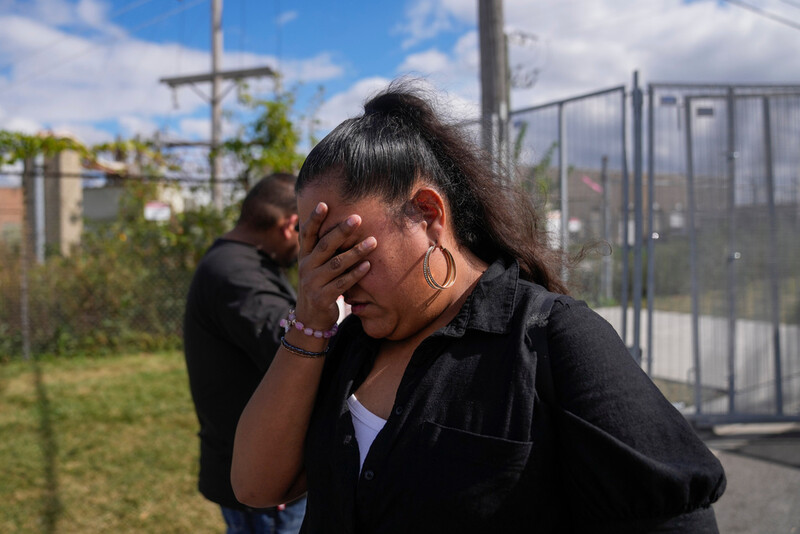 Jessica Aguilar and her son John are emotional after passing diabetes medication for her husband Carlos Aguilar, who she said was taken by unidentified agents in DeKalb on his way to work this morning, to a federal agent through a fence outside the U.S. Immigration and Customs Enforcement (ICE) building Wednesday, Sept. 24, 2025, in Broadview, Ill. (AP Photo/Erin Hooley)