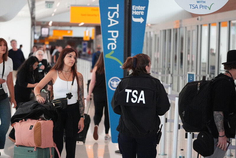 Transportation Security Administration worker guides travelers at a security checkpoint in Denver International Airport Thursday, Oct. 2, 2025, in Denver. (AP Photo/David Zalubowski)