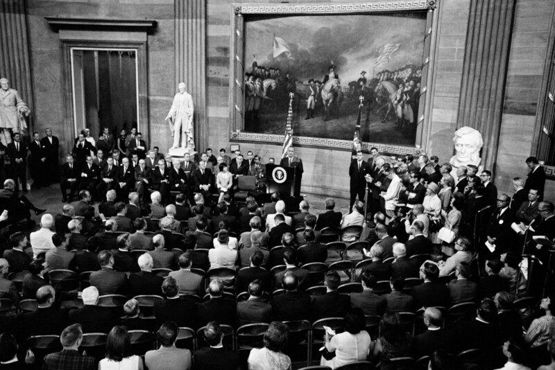 FILE - President Lyndon Johnson, at podium, speaks in the rotunda of the Capitol in Washington, before to signing the Voting Rights Act, Aug. 6, 1965. (AP Photo, File)