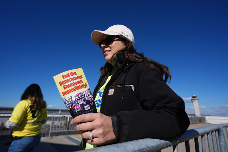 Air Traffic Controller Claudia Peterfeso distributes leaflets explaining how the federal government shutdown is impacting air travel at Detroit Metropolitan Wayne County Airport Tuesday, Oct. 28, 2025, in Romulus, Mich. (AP Photo/Paul Sancya)
