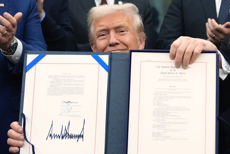 President Donald Trump displays the signed the funding bill to reopen the government, in the Oval Office of the White House, Wednesday, Nov. 12, 2025, in Washington. (AP Photo/Jacquelyn Martin)