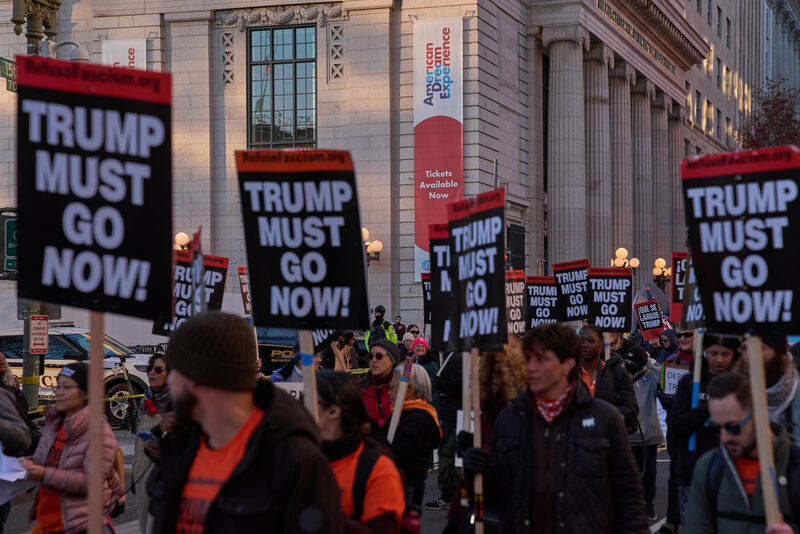Protesters march past the Milken Center for Advancing the American Dream, during a "Trump Must Go Now!" rally by the White House, Monday, Nov. 17, 2025, in Washington. (AP Photo/Jacquelyn Martin)