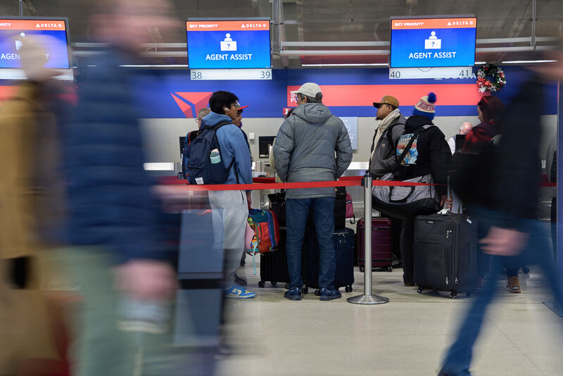 Travelers wait in line at Detroit Metropolitan Wayne County Airport Sunday, Nov. 30, 2025, in Romulus, Mich. (AP Photo/Ryan Sun)