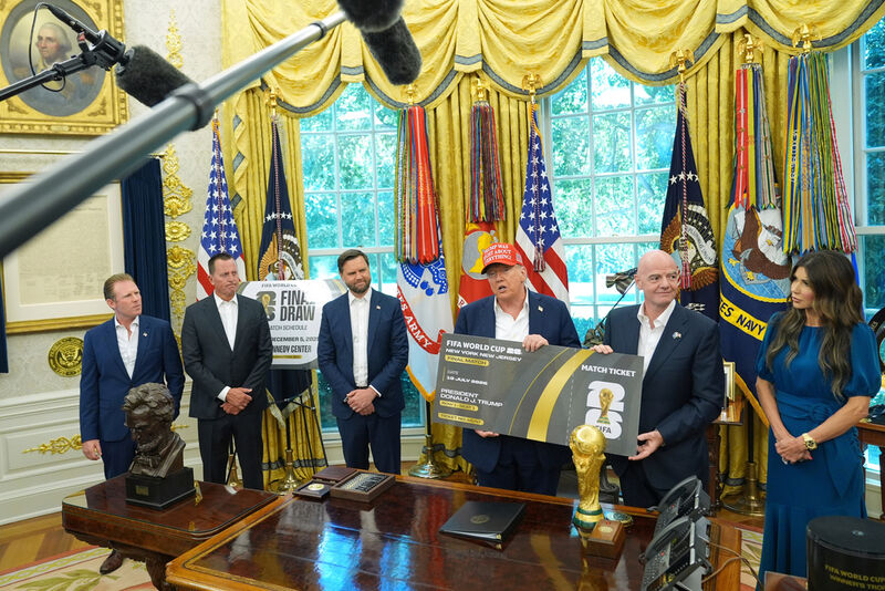FILE - President Donald Trump speaks holding a large ticket representing a ticket for the World Cup final, row one, seat one, as Andrew Giuliani, from left, Richard Grenell, president of the Kennedy Center Board of Trustees, Vice President JD Vance, FIFA President Gianni Infantino and Homeland Security Secretary Kristi Noem listen in the Oval Office of the White House, Aug. 22, 2025, in Washington. (AP Photo/Jacquelyn Martin, file)