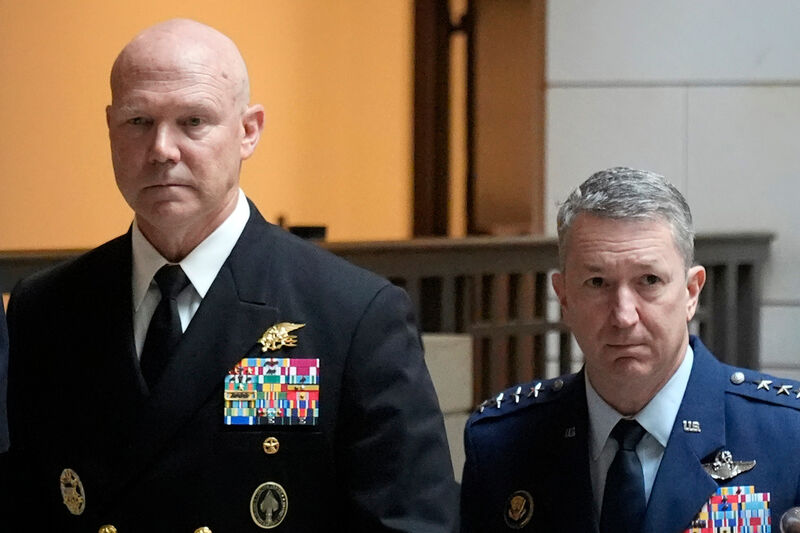 U.S. Navy Adm. Frank M. Bradley, accompanied by Gen. Dan Caine, chairman of the Joint Chiefs of Staff, right, walks to a meeting with senators on Capitol Hill, Thursday, Dec. 4, 2025, in Washington. (AP Photo/Mark Schiefelbein)