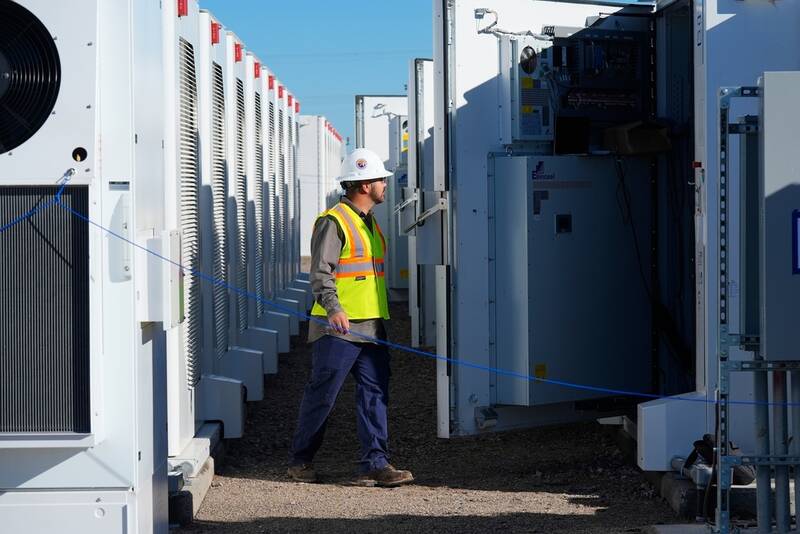 FILE - A worker does checks on battery storage pods at Orsted's Eleven Mile Solar Center lithium-ion battery storage energy facility Feb. 29, 2024, in Coolidge, Ariz. (AP Photo/Ross D. Franklin, File)