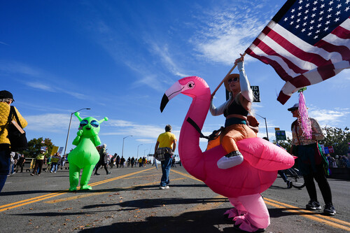 Angee Murray waves an Amercian flag during a "No Kings" protest Saturday, Oct. 18, 2025, in Portland, Ore. (AP Photo/Jenny Kane)