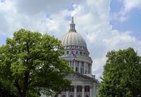 The Progress Pride Flag flies over the Wisconsin Capitol in June 2023. Wisconsin lawmakers held a hearing Thursday on two bills that would limit the rights of trans and non-binary people under the age of 18.. (Photo by Henry Redman/Wisconsin Examiner)miner)