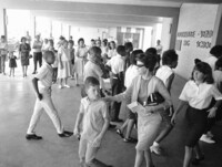 FILE - A white mother walks with her son past a group of African American students arriving for classes at formerly all-white Boothville Venice High School on Monday, Sept. 12, 1966 as racial barriers fell in Plaquemines Parish. (AP Photo/Jack Thornell, file)