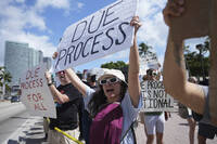 FILE - People hold signs and chant slogans during a protest against the Trump administration, Saturday, April 19, 2025, in Miami. (AP Photo/Lynne Sladky, File)