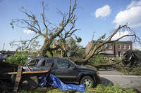 A large tree blocks a road after a severe storm moved through Friday, May 16, 2025, in St. Louis. (AP Photo/Jeff Roberson)