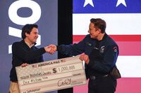 FILE - Elon Musk presents a check for $1 million dollars to a man during a town hall March 30, 2025, in Green Bay, Wis. (AP Photo/Jeffrey Phelps, File)
