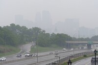 Smoke from wildfires burning in Canada and rain obscures the downtown skyline of Minneapolis, Minn., on Tuesday, June 3, 2025. (AP Photo/Mark Vancleave)