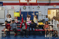 Children raise their hands while participating in activities during the East Providence Boys and Girls Club Summer Camp at Emma G. Whiteknact Elementary School on Thursday, July 10, 2025, in Providence R.I. (AP Photo/Sophie Park)