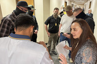 Immigration court volunteer Marjorie Miller gives guidance and support to a Colombian man who was about to be taken into custody by Immigration and Custom Enforcement officers in the hallway after his hearing with an immigration judge in Seattle, June 3, 2025. (AP Photo/Martha Bellisle)