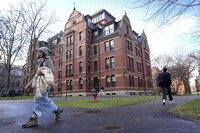 FILE - People walk between buildings on Harvard University campus, Dec. 17, 2024, in Cambridge, Mass. (AP Photo/Steven Senne, File)