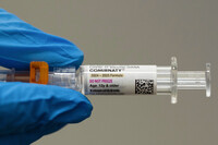 FILE - A pharmacist holds a Pfizer and BioNTech COVID-19 vaccine shot on Thursday, April 24, 2025, in Portland, Ore. (AP Photo/Jenny Kane, File)