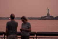 FILE - The Statue of Liberty is visible through haze due to Canadian wildfire smoke during sunset Aug. 5, 2025, in New York. (AP Photo/Yuki Iwamura, File)