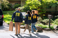 FBI agents carry empty boxes to former national security adviser John Bolton's house, Friday, August. 22, 2025, in Bethesda, Md. (AP Photo/Jose Luis Magana)