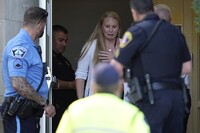 A person walks out of the Annunciation Church's school as police response to a reported mass shooting, Wednesday, Aug. 27, 2025, in Minneapolis. (AP Photo/Abbie Parr)