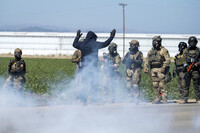 FILE - Federal immigration agents toss tear gas at protesters during a raid in the agriculture area of Camarillo, Calif., Thursday, July 10, 2025. (AP Photo/Michael Owen Baker, File)