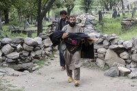 An injured person is carried to a military helicopter that landed to evacuate injured victims of an earthquake that killed many people and destroyed villages in eastern Afghanistan, in Mazar Dara, Kunar province, Monday, Sept. 1, 2025. (AP Photo/Wahidullah Kakar)