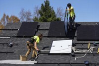 FILE - Theodore Tanczuk, left, and Brayan Santos, right, of solar installer YellowLite, put panels on the roof of a home in Lakewood, Ohio, April 16, 2025. (AP Photo/Sue Ogrocki, File)