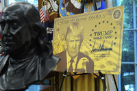 poster showing the Trump Gold Card is pictured as President Donald Trump speaks in the Oval Office of the White House, Friday, Sept. 19, 2025, in Washington. (AP Photo/Alex Brandon)