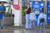 Edwin Cardona, left, who had an appointment at the U.S. Immigration and Customs Enforcement office, stands with his wife Arianny Sierra and their sons, after a shooting at the facility, in Dallas on Wednesday, Sept. 24, 2025. (AP Photo/Julio Cortez)