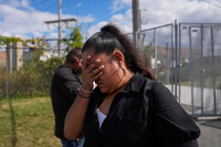 Jessica Aguilar and her son John are emotional after passing diabetes medication for her husband Carlos Aguilar, who she said was taken by unidentified agents in DeKalb on his way to work this morning, to a federal agent through a fence outside the U.S. Immigration and Customs Enforcement (ICE) building Wednesday, Sept. 24, 2025, in Broadview, Ill. (AP Photo/Erin Hooley)