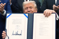 President Donald Trump displays the signed the funding bill to reopen the government, in the Oval Office of the White House, Wednesday, Nov. 12, 2025, in Washington. (AP Photo/Jacquelyn Martin)