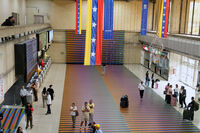Travelers wait in the main hall of the Simon Bolivar Maiquetia International Airport in Maiquetia, Venezuela, Sunday, Nov. 23, 2025, after several international airlines canceled flights following a warning from the U.S. Federal Aviation Administration about a hazardous situation in Venezuelan airspace. (AP Photo/Ariana Cubillos)